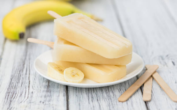 istock Banana Popsicles on wooden background 870878442