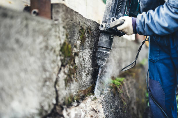 istock Worker using industrial construction tool, industrial jackhammer with demolition debris and cement 870884154