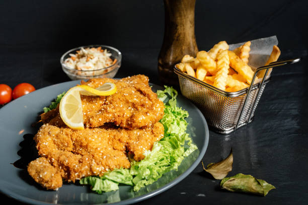 escalope de ternera como plato principal con patatas fritas y ensalada de col - viennese schnitzel fotografías e imágenes de stock