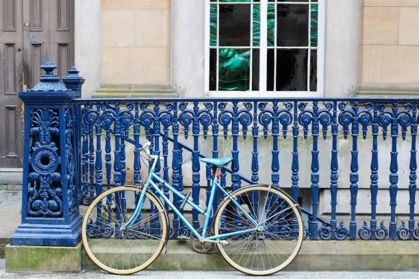 istock Blue Bicycle Rests Against Dark Blue Iron Fence on Sidewalk 870887440
