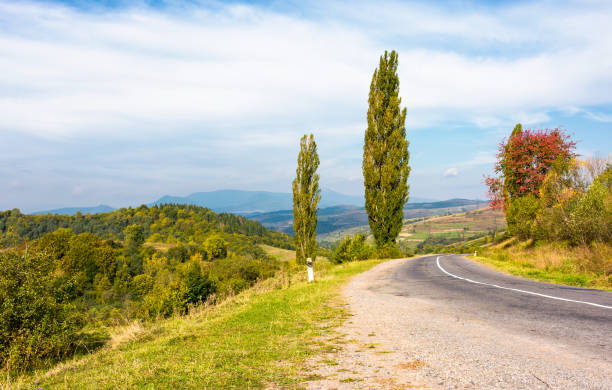 istock asphalt country road through hills with trees 870888378