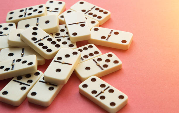 istock Dominoes on Pink background. Flat lay 870894386