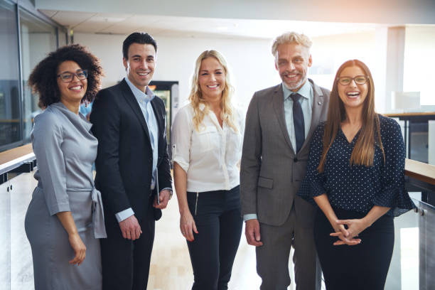 istock Diverse group of smiling colleagues standing together in an office 870894746