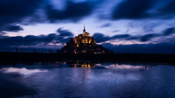 istock Mont Saint Michael with water reflection during night time  center image 870901716
