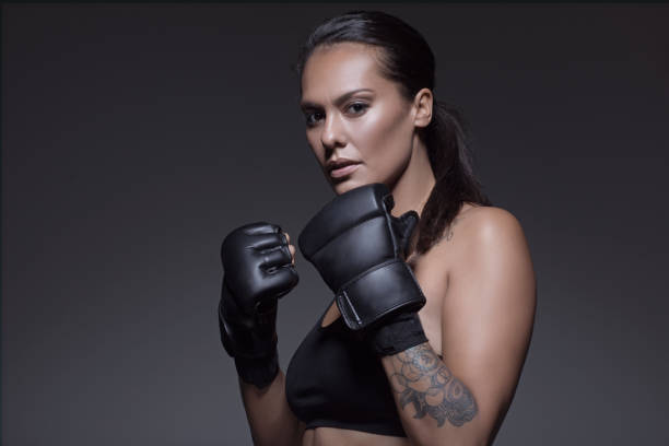 hermosa morena mujer combatiente posando para potrait - mujer luchadora fotografías e imágenes de stock