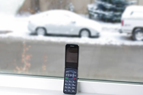 Old cell phone with car in snow