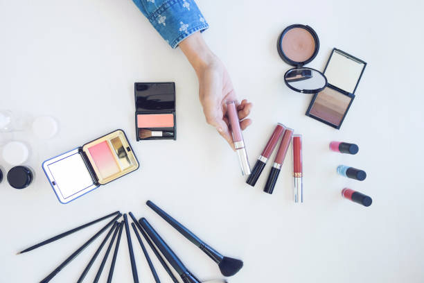 istock Many makeup cosmetics different on white wooden table background, top view 870907474