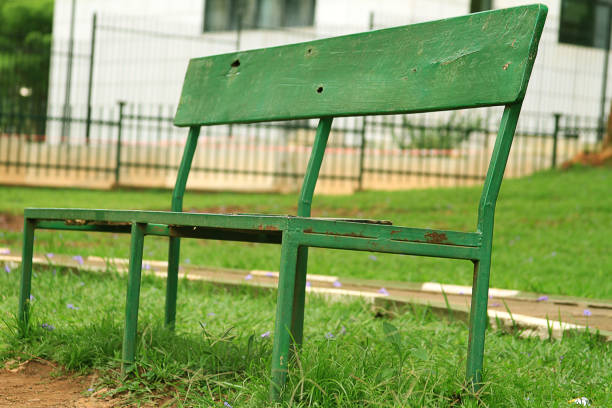 istock An old green park bench in the gardens. 870909260
