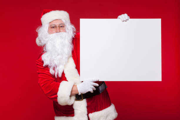 istock Santa Claus pointing in blank advertisement banner isolated on red background with copy space 870909590