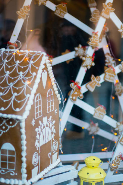istock Snowy Gingerbread house with snowflakes christmas tree and globe on stone wall background. Homemade christmas cookies - gingerbread on snow background. Closeup xmas gingerbread cottage in wintertime 870912642