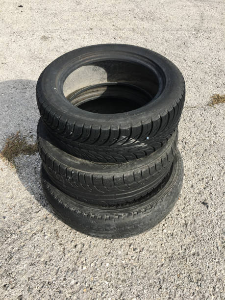 istock three old tires on an asphalt road. 870915798