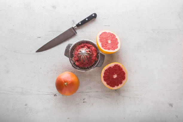 Top Of View Grapefruit Knife And Juicer On White Concrete Background Stock  Photo - Download Image Now - iStock