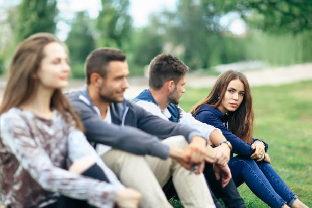 istock Young people sitting on lawn in park closeup 870923226