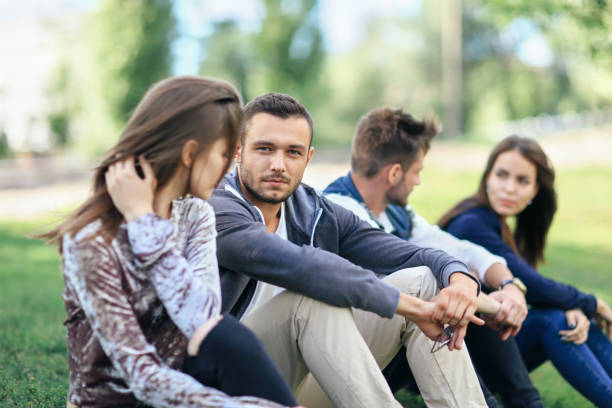 istock Young men and women talking and resting on lawn 870923232