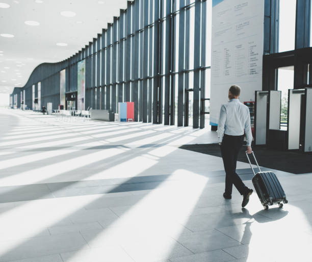 istock Business man walking with wheeled bag 870934140