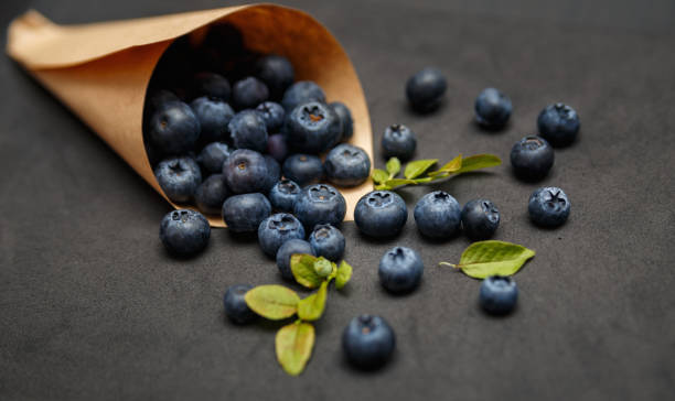 Fresh blueberries with leafs on dark background stock photo