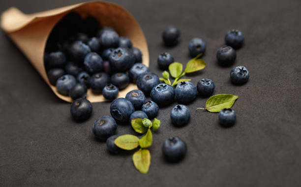 Fresh blueberries with leafs on dark background stock photo