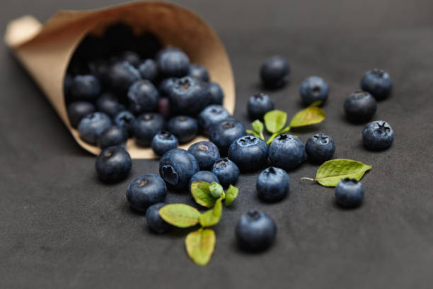 Fresh blueberries with leafs on dark background stock photo