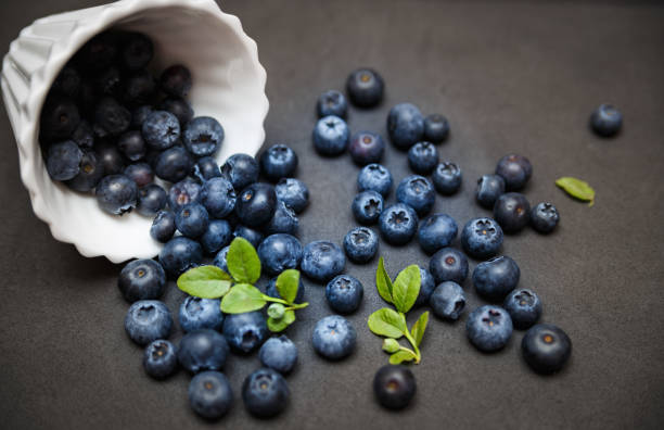 Fresh blueberries with leafs on dark background stock photo