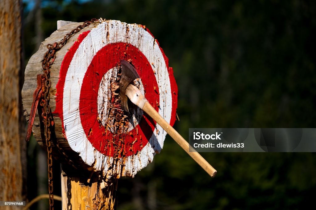 Thrown Axe in Bullseye Double-bladed axe that hit the bullseye. Axe Stock Photo