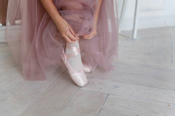 istock Ballerina puts pointe shoes 870947846