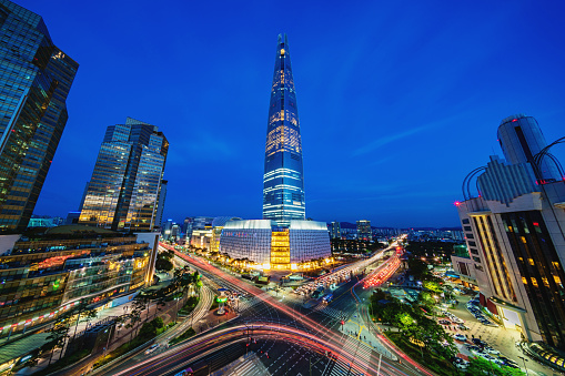 Songpagu district cityscape in Seoul at night. Motion blurred traffic lights, illuminated skyscrapers and Lotte world tower. Seoul, South Korea, Asia. Aerial view with 10 mm ultra wide angle 42 MP Sony A7RII.