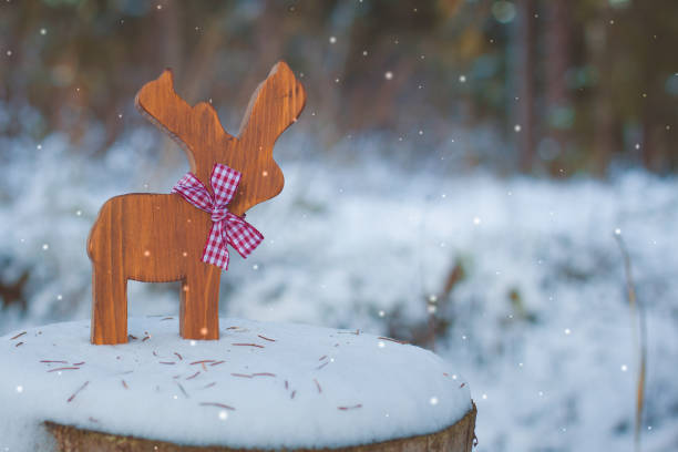 istock Christmas-tree toy deer with a ribbon on the snow. With a copy-space. 870961054