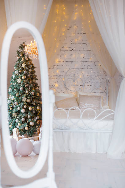 istock Christmas bedroom in soft light colors. Big comfortable double bed in elegant classic interior 870967732