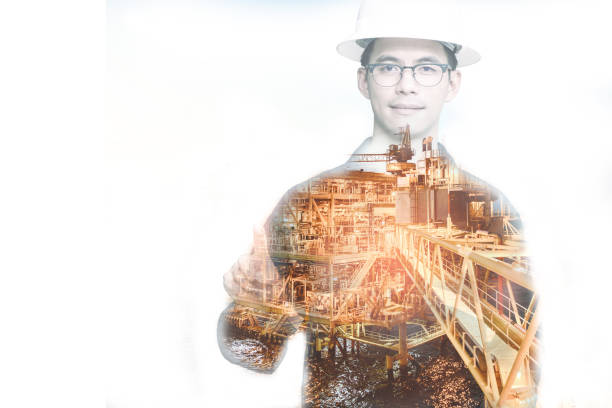 istock Double exposure of Engineer or Technician man with safety helmet pointingfinger on platform or plant by using tablet with offshore oil and gas platform background for oil and gas business concept. 870968516
