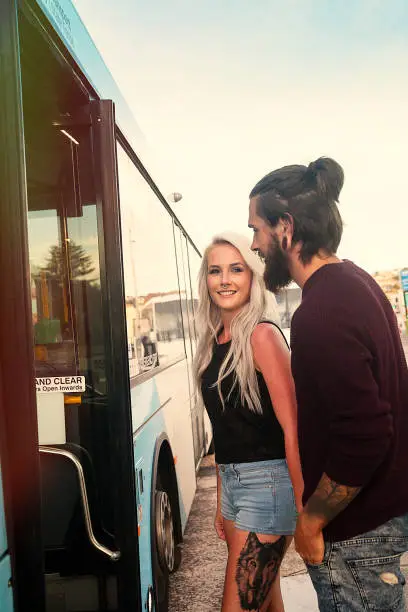 Couple standing at the bus stop getting in the bus at Bondi Beach Sydney