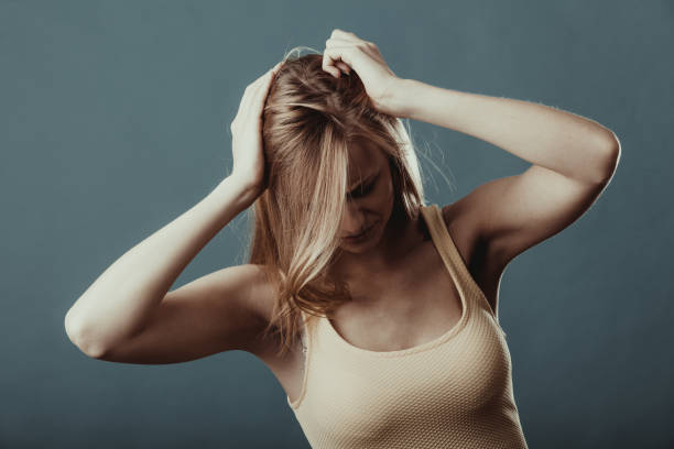istock Closeup stressed girl holds head with hands 870979246