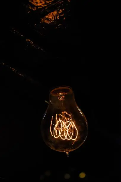 Closeup of a lightbulb surrounded by darkness