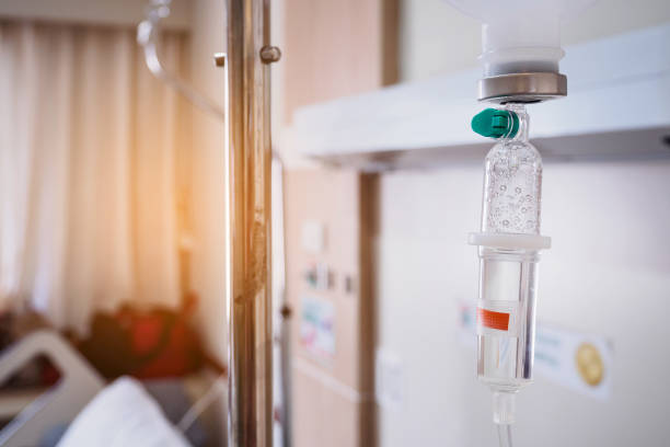 istock Medical drip with hospital blurred background 871012034