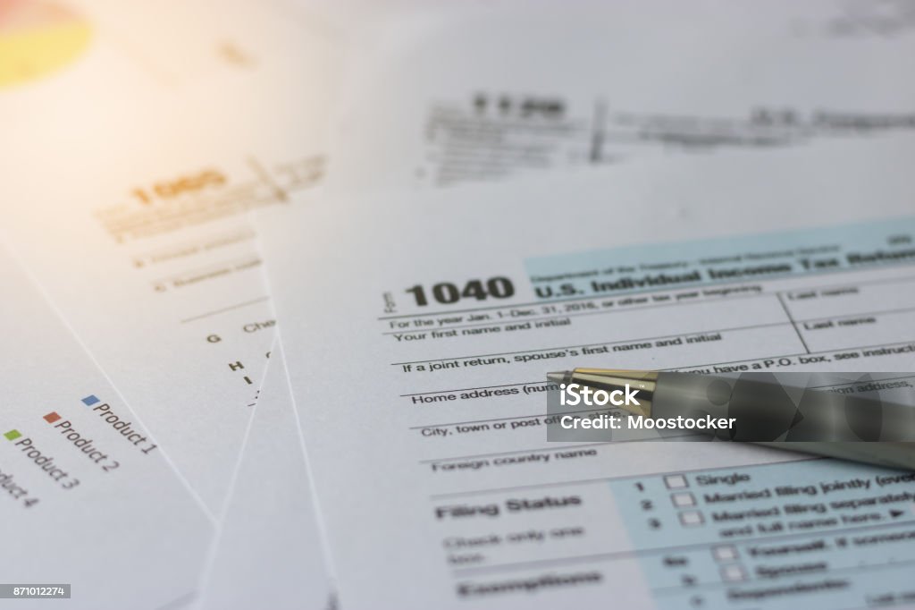 Selective focus a pen on US tax form 1040 on top for background / taxation concept Internal Revenue Service Stock Photo