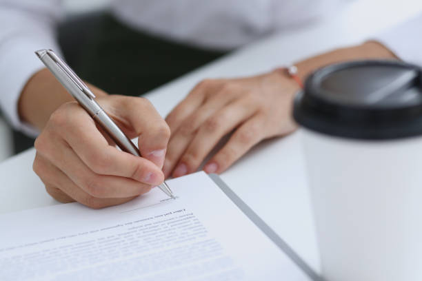 istock Female hand holding silver pen ready to make 871012338