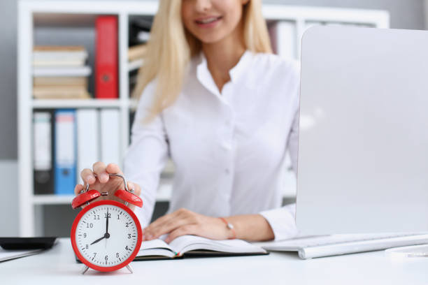 istock Smiling business woman holding in hand clock 871012396