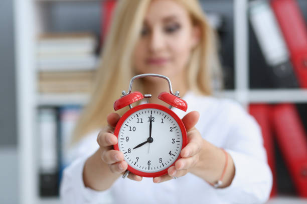 istock Smiling business woman holding in hand clock 871012404