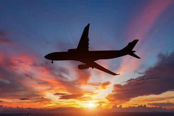 istock The silhouette of a passenger plane flying in sunset. 871012514