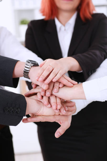 istock Group of people in suits crossed hands pile 871012694