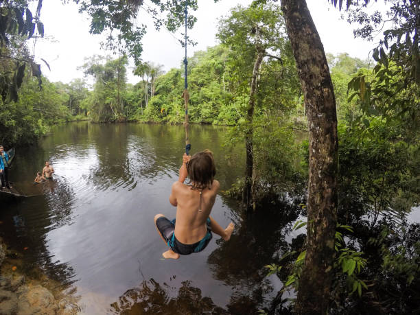 familie genießt eine geführte erkundung des amazonas-dschungels auf einem abgelegenen teil des flusses. - seilschaukel stock-fotos und bilder