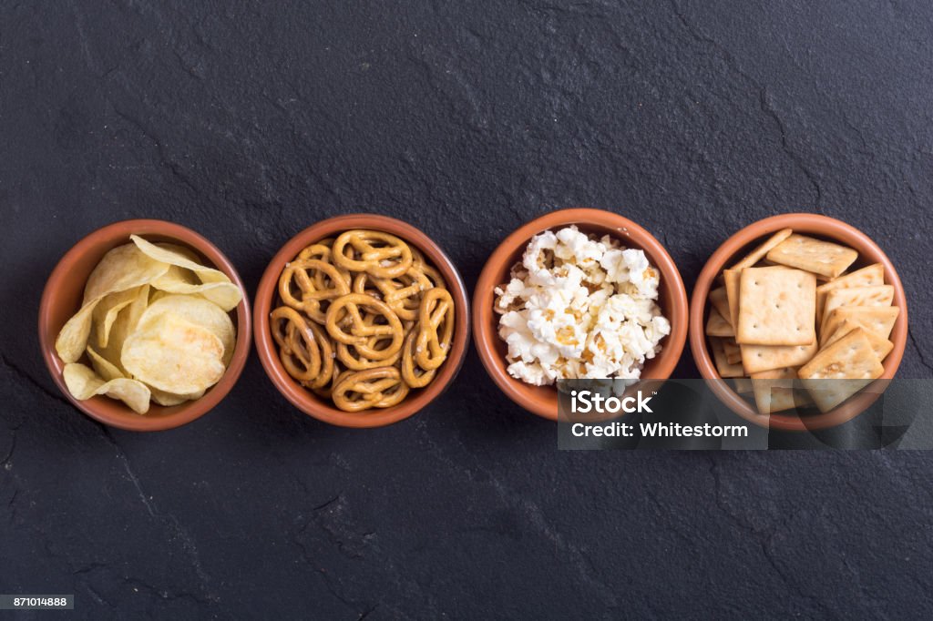 Mix of snacks Frame . Mix of snacks : pretzels , crackers , chips and pop corn Bowl Stock Photo