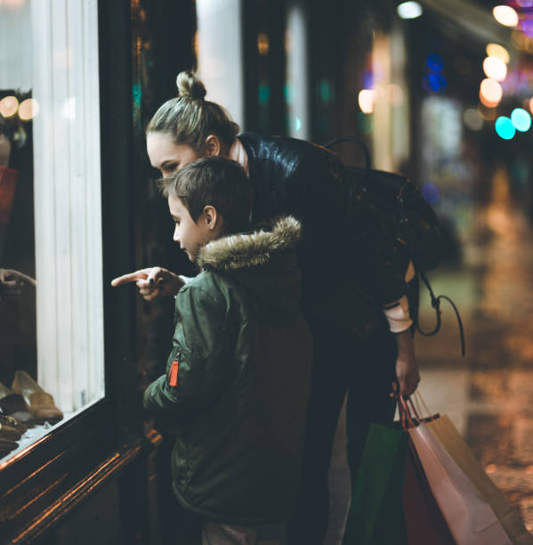 istock Mother and her son looking christmas store window 871015646