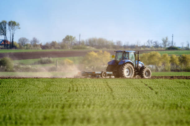 istock Tractor harrowing the land 871025368
