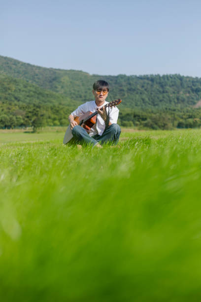 istock young man playing acoustic guitar on lawn 871027868
