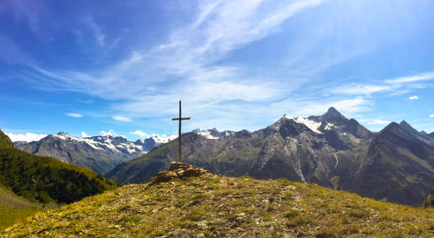 istock Cross on a mountain in front of Italian Alps 871031088