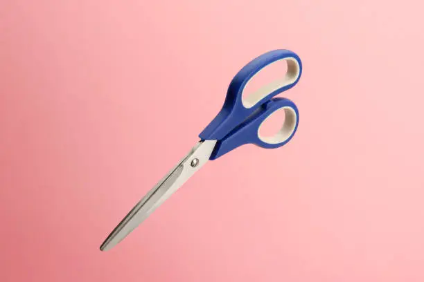 Pair of scissors isolated on a pink background