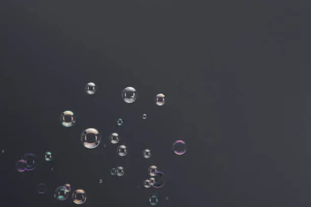Rising soap bubbles over a gray background