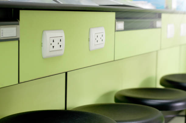 Electrical outlet plug on green table in Laboratory room with black chairs ,side view Electrical outlet plug on green table in Laboratory room with black chairs ,side view Faceplate stock pictures, royalty-free photos & images