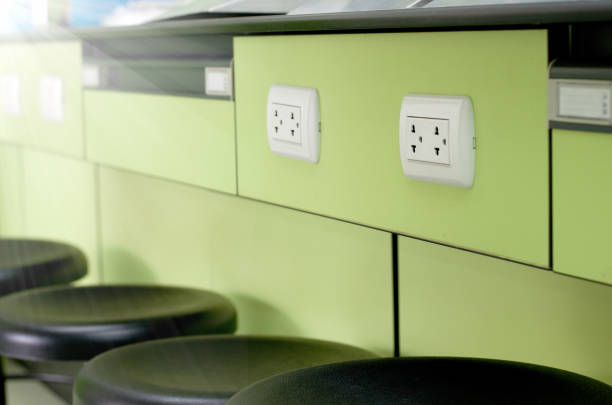 Electrical outlet plug on green table in Laboratory room with black chairs ,side view Electrical outlet plug on green table in Laboratory room with black chairs ,side view Faceplate stock pictures, royalty-free photos & images