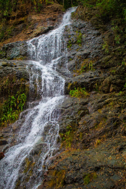 istock Tall waterfall on mountain. Waterfall stream detailed photo 871044124